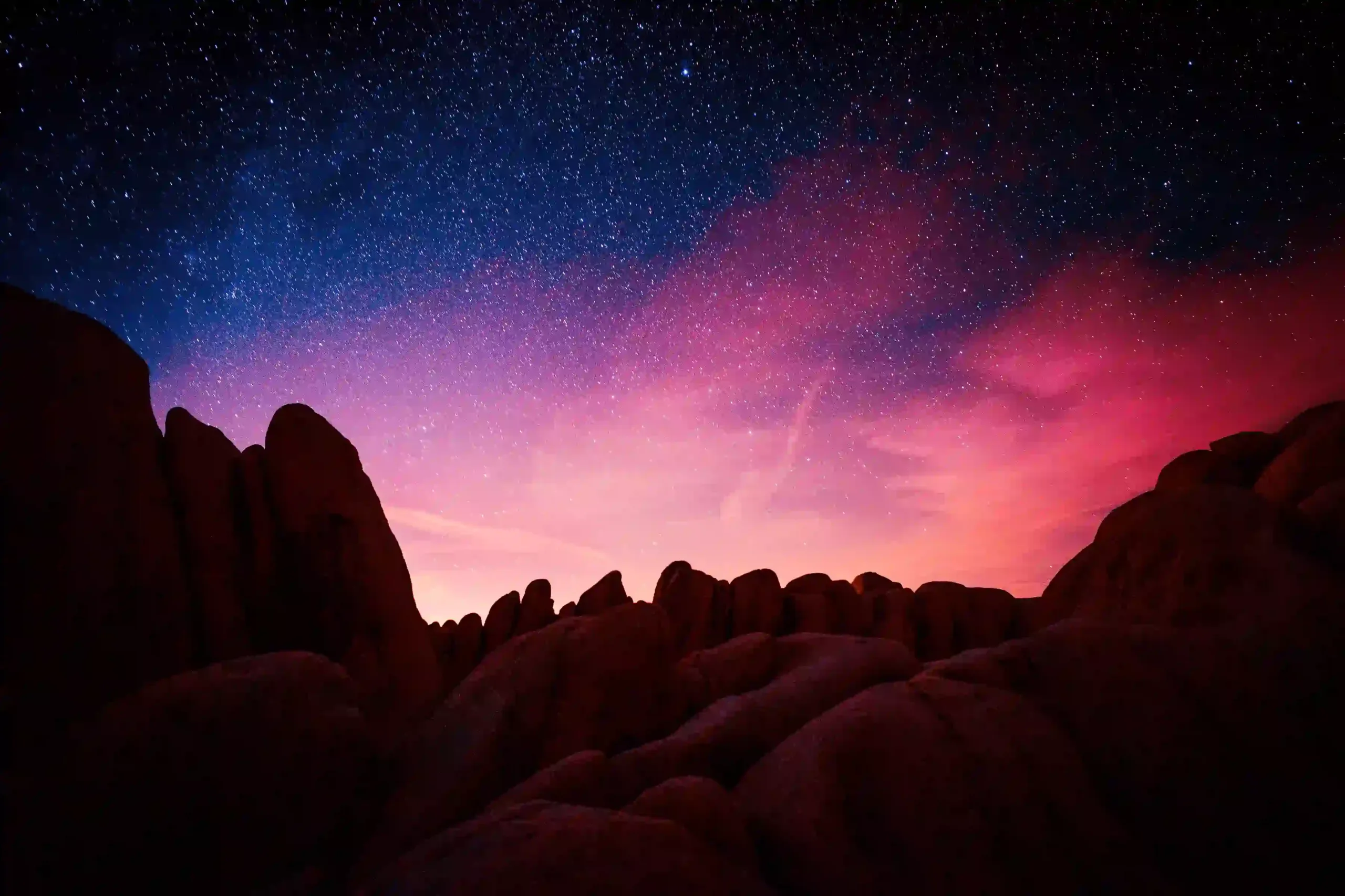 dark red rocks with bright starry sky behind